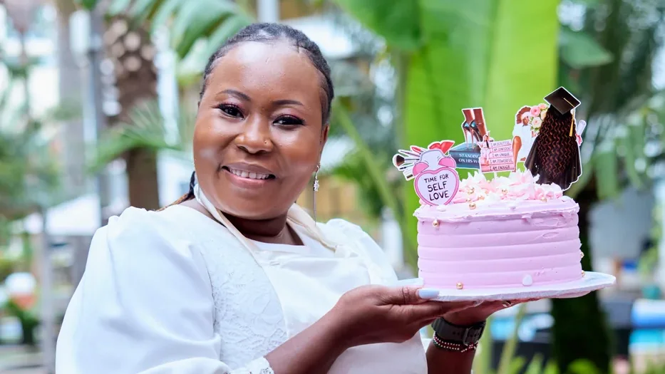 A woman celebrating with her self-love cake at an Eladation experience