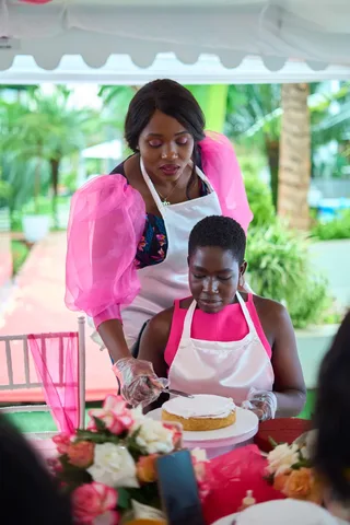 Women decorating a celebration cake together