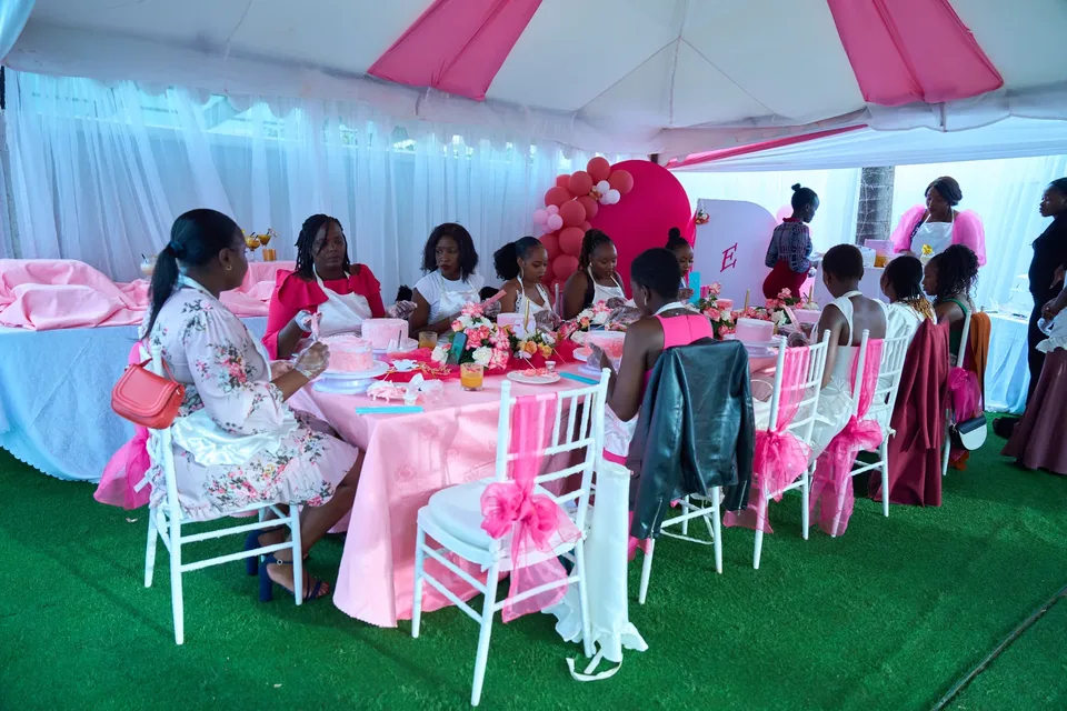 Women enjoying a Cake and Sip gathering around a pink table